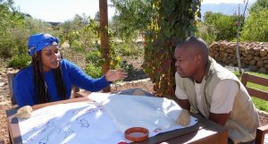 Shoki Mafogo und Vusi Tshabalala von Kruger2 Canyon (Südafrika) sitzen an einem Tisch und planen, wie sie Ressourcenkonflikte zur Sprache bringen können.